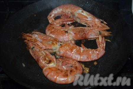 Затем сливаем сок, выделившийся из креветок. На сковороде, разогретой с растительным маслом, на среднем огне обжариваем креветок прямо в панцире с двух сторон  (примерно, по 2-3 минуты с каждой стороны).