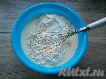 Добавить кефир комнатной температуры, перемешать получившуюся жидкую смесь. Смешать муку с разрыхлителем и добавить в жидкую смесь.