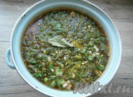 Когда картофель с курицей будут готовы, добавить в кастрюлю зелень с щавелем, лавровый лист, специи, приправу и приготовленную заправку для борща.