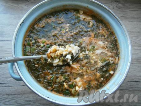 Варить зеленый борщ с щавелем на слабом огне 10 минут, после чего добавить в него рубленные вареные яйца, проварить еще минуты 4 и выключить газ.