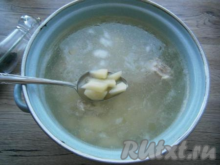 Когда вода закипит, снять пену, бульон посолить, добавить нарезанный кусочками картофель. Варить на слабом огне 25-30 минут.