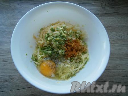К кабачкам с картошкой добавить измельченный зеленый лук, соль, перец, паприку и сырое яйцо.