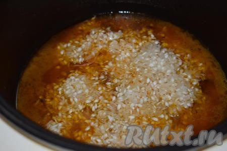 К тушеному мясу и овощам добавляем рис и очищенные зубчики чеснока (чеснок по желанию).