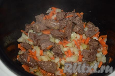 К подрумянившейся говядине добавляем лук и морковь.