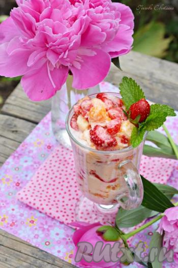 Выкладываем фруктовый салат со сметаной в салатник, креманку или бокал (я подала салат в айриш бокале), украшаем веточкой мелисы или мяты и ягодкой клубнички.