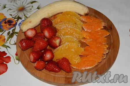 Очищаем от кожуры банан, апельсин и мандарин. Дольки цитрусовых очищаем от плёночек, клубнику - от плодоножек.