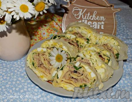 По истечении времени нарезаем готовый рулет из лаваша с рыбными консервами на порционные кусочки и подаем к столу в качестве закуски.