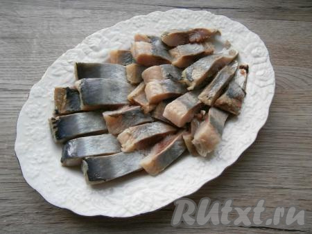 Нарезать филе сельди небольшими кусочками, выложить на блюдо.