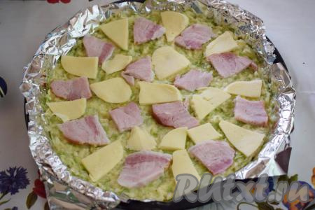 На тесто выкладываем ломтики грудинки (или колбасы) и сыра.