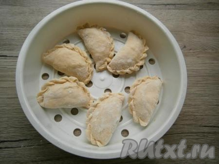 Чашу для варки на пару немного смазать растительным маслом и выложить вареники, чтобы они были друг от друга на расстоянии не менее 3-4 см.