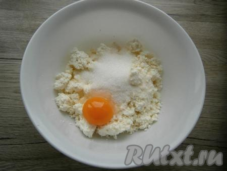 Для приготовления начинки в творог добавить сахар, ванильный сахар и сырой желток.
