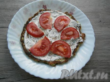 Каждый кабачковый блин смазать соусом, выложить тонкие дольки свежих помидоров, которые немного посолить и поперчить. Сложить кабачковые блины с помидорами друг на друга, формируя торт.