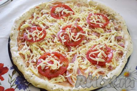 На сыр выложить помидоры, нарезанные кружочками (помидоры можно слегка присыпать сыром). Поставить пиццу с колбасой, помидорами и сыром в духовку, разогретую до 180 градусов, и выпекать, примерно, 25-30 минут.
