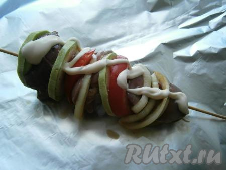 Далее&nbsp;нанизать кусочки куриной печени&nbsp;на деревянные шпажки или шампуры, поочередно с кружочками кабачка, свежего помидора и колечками лука. Если готовите в духовке, каждый шашлычок нужно поместить на&nbsp;фольгу, смазать сверху чуть майонезом.