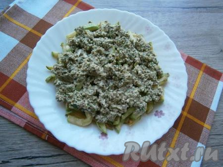 Далее&nbsp;на плоскую тарелку выложить обжаренные кабачки, сверху распределить приготовленную пасту из грецких орехов, чеснока и зелени.
