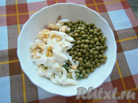 Вареные яйца, очищенные от скорлупы, нарезать продолговатыми кусочками и вместе с консервированным горошком выложить в салат из огурца и полукопченой колбасы.