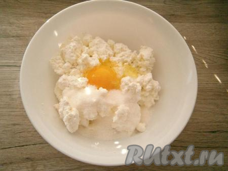 В творог добавить сахар, щепотку соли и сырое яйцо.