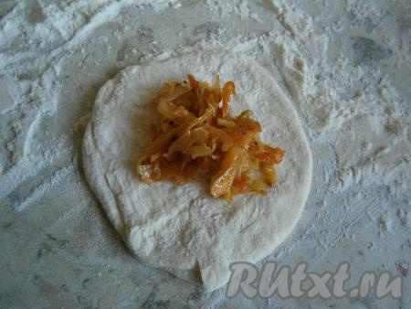 Тесто обмять, разделить на кусочки весом около 55-60 грамм. На столе, присыпанном мукой, каждый кусочек теста раскатать в лепешку. На середину лепешки выкладывать по 1 столовой ложке начинки из капусты.