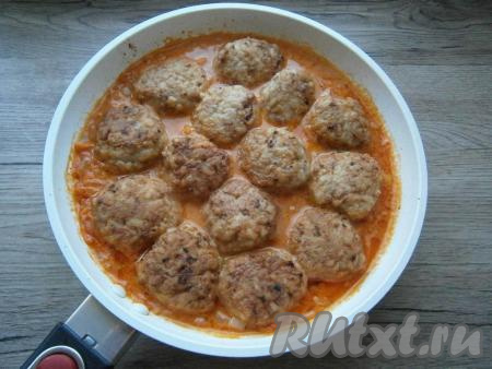 Перемешать сливочно-томатный соус, выложить в сковороду обжаренные тефтели в один слой.