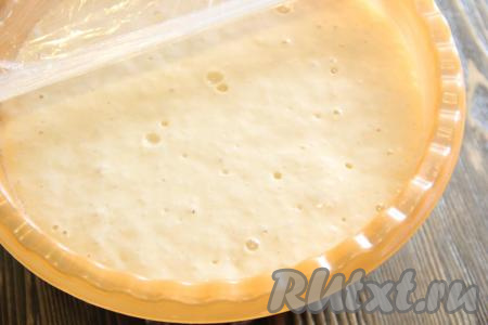 Накрыть миску с тестом для шанежек пищевой плёнкой и оставить на 1 час в тёплом месте. Тесто немного увеличится в объёме и запузырится.&nbsp;