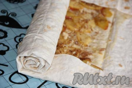 Свернуть лаваш с начинкой в плотный рулет, подвернув предварительно края лаваша с двух сторон (как на фото).