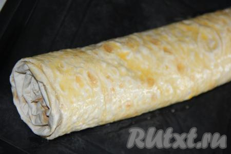 Выложить рулет из лаваша с яблоками на противень и смазать его оставшейся яичной массой. Противень нужно предварительно смазать растительным маслом.