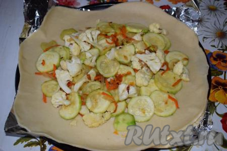 Перекладываем фольгу с тестом в форму и на середину галеты выкладываем нашу овощную начинку, оставляя края теста пустыми (как на фото).