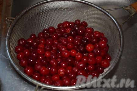 Подготовленные ягоды промываем в дуршлаге под горячей водой - так мы прогреем вишню и при заливке ягод в банке кипятком температура воды уменьшится незначительно, а значит тепло в банке сохранится дольше - именно это нам и нужно, ведь вишневый компот по этому рецепту готовится без стерилизации.