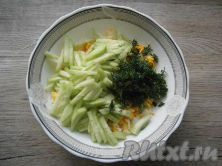 Огурец нарезать соломкой или брусочками и добавить к яйцам вместе с измельченным укропом.