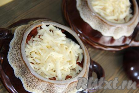 Залить пельмени тёплой водой или бульоном. Вода должна заполнить 1/2 горшочка. Сыр натереть на тёрке и выложить поверх зажарки. Накрыть горшочки крышками и поставить в разогретую духовку. Запекать пельмени с грибами 30 минут при температуре 220 градусов.
