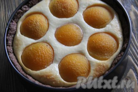 Выпекать пирог с творогом и консервированными персиками, примерно, 1 час в духовке, разогретой до 200 градусов.