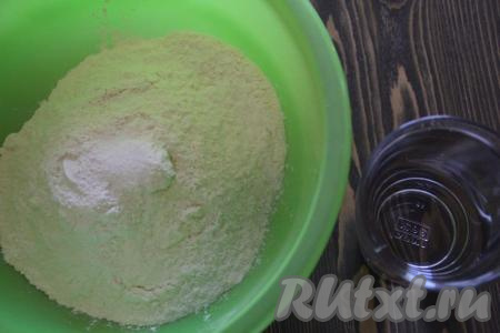 В глубокую миску всыпать муку и соль. Постепенно вливать холодную воду и постоянно перемешивать.