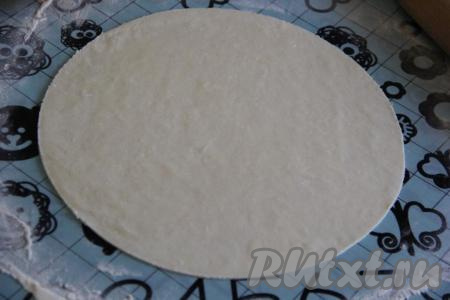 Тесто разделить на небольшие кусочки, а затем тонко раскатать на столе, присыпанном мукой. Я раскатала тесто, а затем обрезала края по тарелке диаметром 20 см.