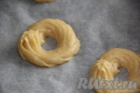 Противень застелить пергаментом. Аккуратно отсадить тесто на противень в виде колечек.
