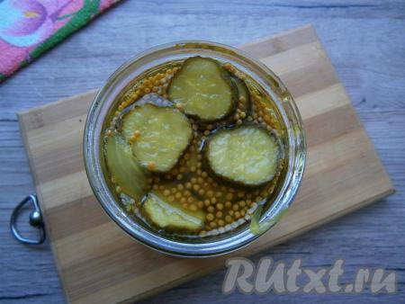 Разложить огурцы в простерилизованные баночки вместе с маринадом, закатать ошпаренными крышками.