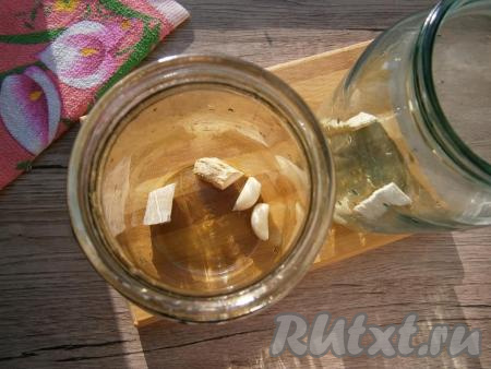 Огурцы замочить в холодной воде часа на 2. Банки чисто вымыть (можно не стерилизовать). На дно банок выложить очищенные зубчики чеснока и кусочки корня хрена.