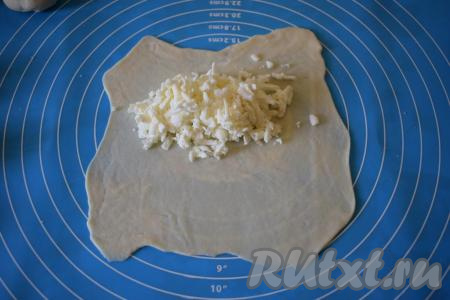 Присыпаем мукой поверхность, на которой будем работать с тестом. Каждую часть теста раскатываем в тонкий круг диаметром 17-18 см, сильно выравнивать края необязательно (сэкономим на этом время), так как мы все равно будем обрезать края по кругу при помощи тарелки или катка для чебуреков. На половину круга выкладываем начинку. Начинки надо класть, примерно, по 2 чайные ложки,&nbsp;визуально это будет смотреться как будто начинки многовато, не переживайте, так как в процессе жарки сыр немного подплавляется.