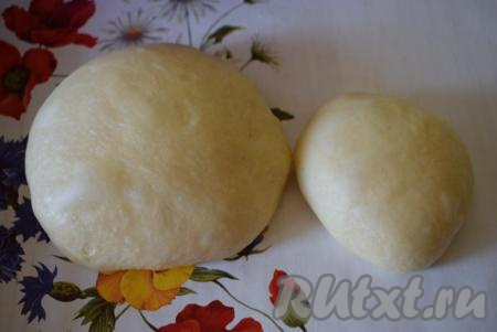 Приступаем к приготовлению нашего вишневого пирога. Для этого разделим подошедшее дрожжевое тесто на 2 части (большая часть теста станет основой пирога, маленькую часть теста будем использовать для оформления верха выпечки).