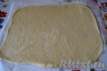 Большую часть теста раскатываем на пергаменте по размеру противня для выпечки.