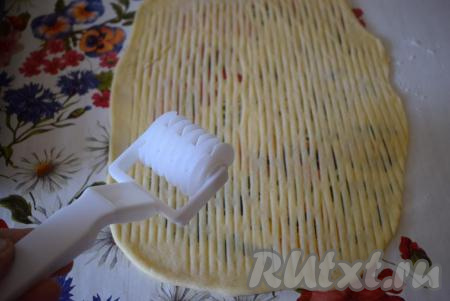 Далее оформляем верх пирога, для этого можно раскатать меньшую часть теста, нарезать жгутики и выложить сверху, образуя решетку, а можно воспользоваться специальным&nbsp;роликом для сеточки (как на фото).