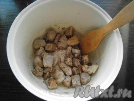 В чашу мультиварки влить растительное масло, выложить кусочки свинины, посыпать их хмели-сунели. Выставить режим "Выпечка" или "Жарка" на 20 минут. Обжаривать мясо, помешивая, 10 минут.