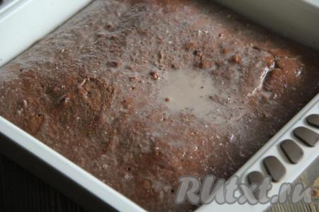 Готовый бисквит перевернуть, снять пергамент и вернуть обратно в форму. Залить бисквит пропиткой. Оставить бисквит на пару часов при комнатной температуре, а затем поставить в холодильник на ночь.