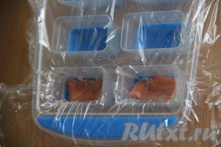 Рис&nbsp;промыть под холодной проточной водой. Поместить&nbsp;рис в кастрюлю и залить водой в пропорциях&nbsp;1 к 2 (1 часть риса на&nbsp;2 части воды).&nbsp;Поставить кастрюлю на огонь, после закипания воды уменьшить&nbsp;огонь и варить рис на среднем огне под прикрытой крышкой, примерно, 15-20 минут (вода должна полностью выпариться). По желанию, в&nbsp;готовый&nbsp;рис можно добавить рисовый уксус, перемешать, накрыть полотенцем и дать полностью остыть. Форму для льда застелить пищевой плёнкой. На дно каждой лунки выложить по кусочку красной&nbsp;рыбы.