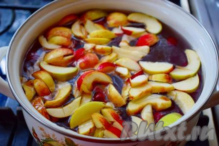 В кипящий сироп кладем вишню с косточками и яблоки, доводим компот до кипения.