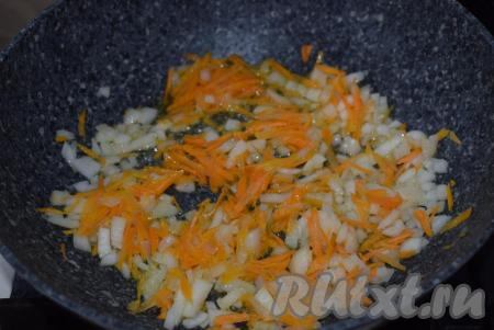 Помидоры натираем на крупной терке. В глубокой сковороде разогреваем растительное масло и выкладываем лук с морковью, обжариваем их на среднем огне до прозрачности лука, накрыв сковороду крышкой, периодически помешивая.