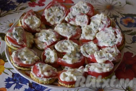 Помидоры покрываем сметанно-чесночным соусом.