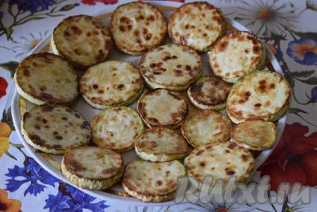 Приступаем к сборке закуски. На блюдо для подачи выкладываем обжаренные кабачки.