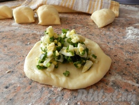 Кусочек теста размять руками в небольшую круглую лепешку, на середину выложить начинку.
