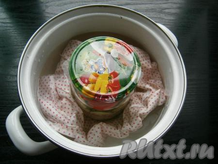 Прикрыть банки крышками и поставить на стерилизацию. Для этого в кастрюлю налить воду, на дно поместить тряпочку, поставить на огонь, дать воде закипеть, уменьшить огонь до среднего. Аккуратно поместить баночки в кипяток (вода должна доходить до "плечиков" банок) и стерилизовать 10 минут от начала кипения воды на среднем огне.&nbsp;