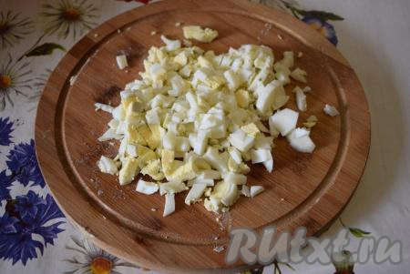 Нарезать яйца мелкими кубиками.